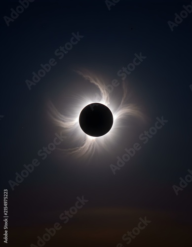 Dramatic astronomical photograph of a total solar eclipse, with the Moon covering the Sun and a brilliant, detailed solar corona, realistic atmospheric conditions and scientifically accurate details.