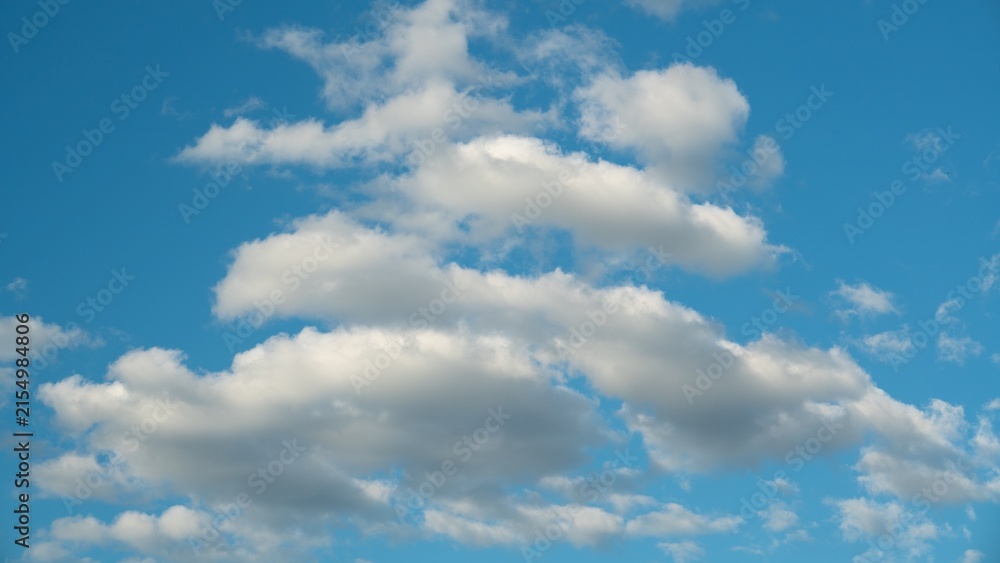 Obraz premium Clouds in a blue sky during the day with varying shapes and sizes in a natural scene