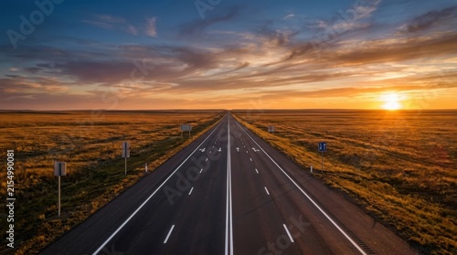 Endless Highway Stretching Towards a Fiery Sunset Over A Vast Open Landscape