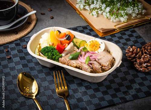 фотографія Healthy bento box lunch with roasted pork, vegetables, and hard-boiled eggs on d