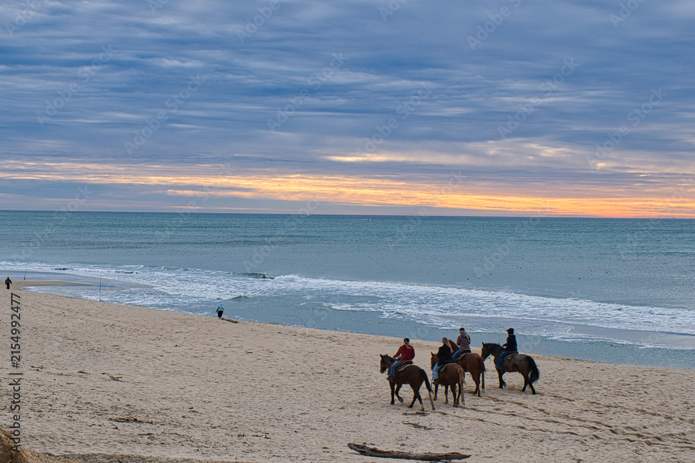Fototapeta premium Horse riding in Half Moon Bay at Sunset