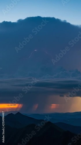 A powerful thunderstorm with lightning strikes over mountains
