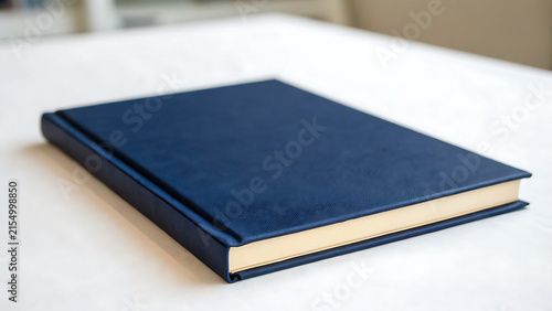 Closed dark blue hardcover notebook on white desk for professional business or study use