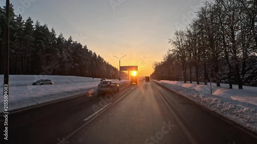 Winter frosty snowy sunset, orange landscape and road.