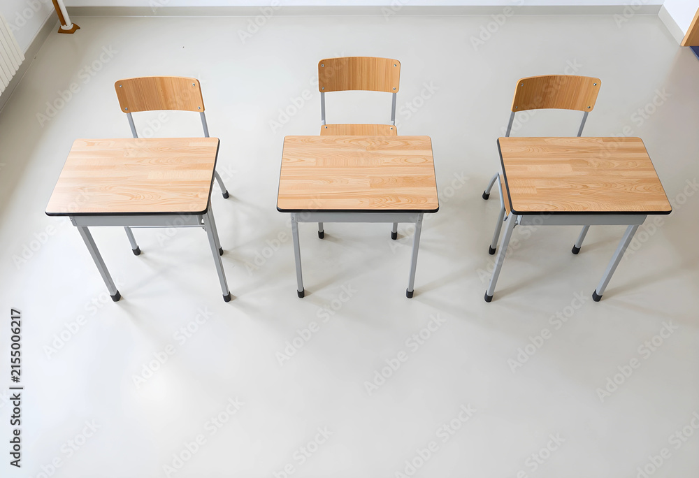 Obraz premium Three empty wooden school desks and chairs in a classroom, education and learning environment, social distancing