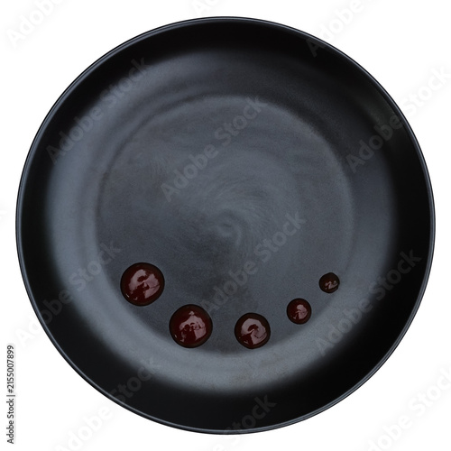 red sauce decoration on black circle plate isolated on white.