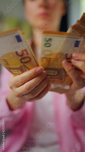 Woman counting euro bills, close-up. Vertical