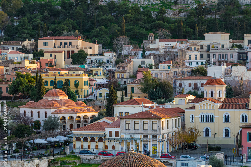 Obraz premium Elevated view of the historic Plaka neighborhood in Athens, Greece, featuring traditional colorful houses and the Fethiye Mosque with its multiple domes at golden hour.