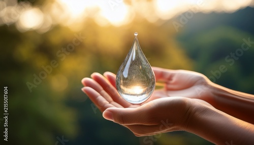 a close up shot of cupped hands holding a sparkling translucent water droplet with a blurred natural background