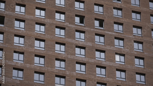 Large residential building under construction with repetitive windows and unfinished exterior representing modern housing development and urban growth