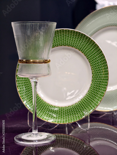 Obraz na plátně Premium glassware displayed in front of green dinner plates on a sophisticated t
