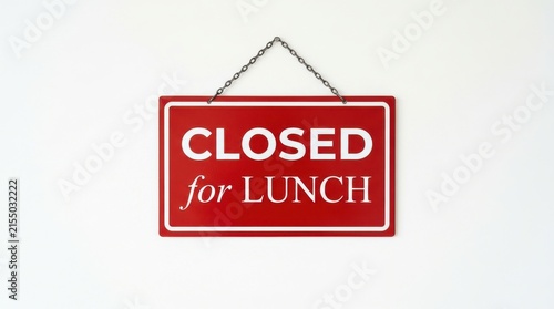 A rectangular red sign with white lettering indicates a business is closed for lunch hanging against a white wall closedsign lunchbreak restaurantnotice