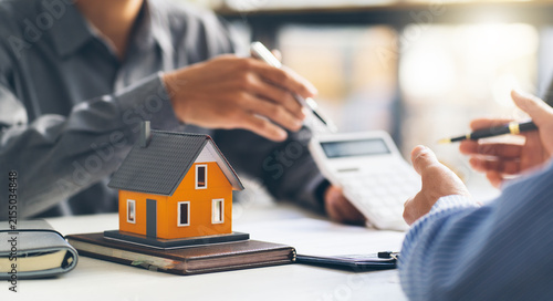 Foto Real estate agent talked about the terms of the home purchase agreement and asked the customer to sign the documents to make the contract legally, Home sales and home insurance concept
