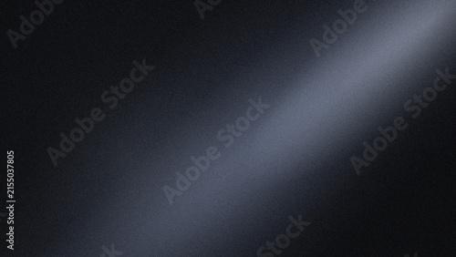 A soft white beam of light shining diagonally across a dark, grainy, and textured black background surface