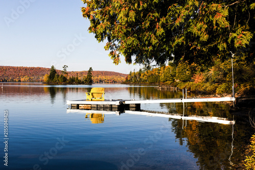 Foto Chaise jaune sur le bout d'un quai sur un lac calme en automne