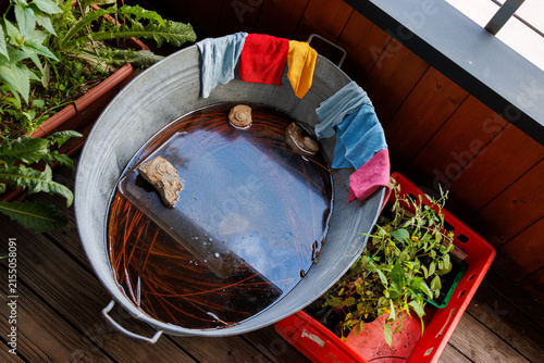 Colorful microfiber kithcen cleaning cloths on galvanized water tub on the balcony