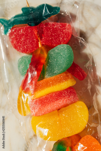 Photography close up of plastic wrapped gummy candy on skewer, candy kabob