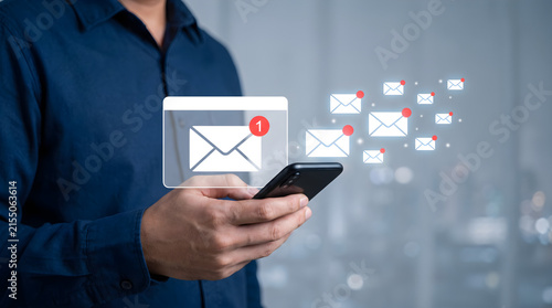 Professional man using mobile phone to manage digital email messages and inbox notifications on virtual display with bokeh city office background