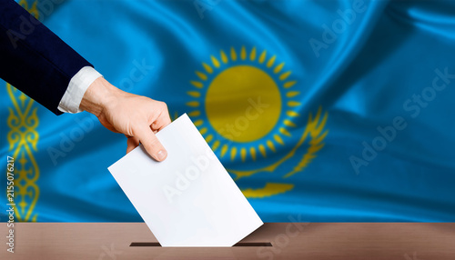 Quadro su tela Hand placing a ballot in ballot box with the Kazakh flag in the background