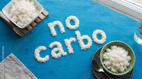 Rice arranged on blue table spelling no carbo message.