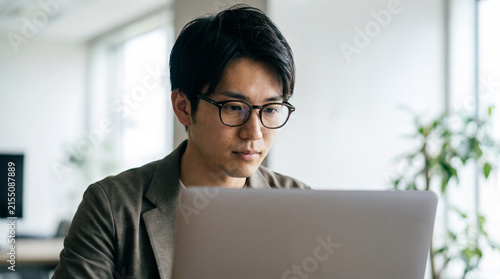 ITエンジニア・SEの男性がオフィスでノートPCを操作するビジネスシーン