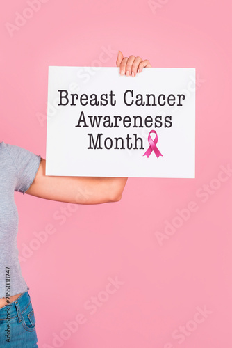 Health campaign photo featuring woman showcasing sign for Breast Cancer Awareness Month