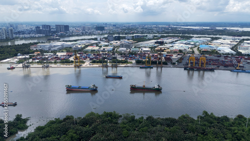 An aerial view of Cat Lai Port, a major container port in Ho Chi Minh City, Vietnam. Cargo ships are moored along the Saigon River.
