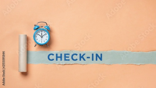 Check-in text on torn paper with blue alarm clock on peach background