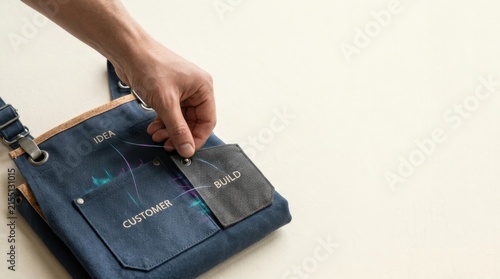 Individual attaching pocket to apron to illustrate next-generation entrepreneurship built on practical skills and creativity