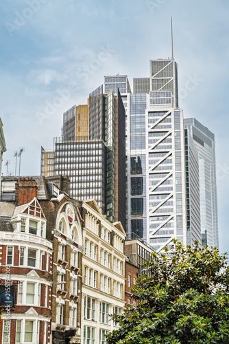 View of historic brick buildings contrasted with modern glass skyscrapers in the financial district near Liverpool Street in London, England, United Kingdom.