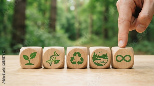 Hand pointing at wooden cube with sustainability icons on forest background