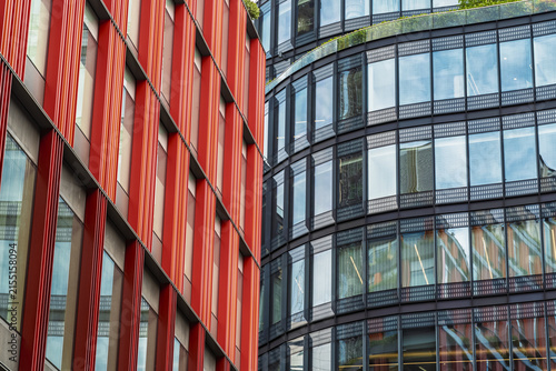 View of modern glass office buildings with striking red facade elements and reflective windows near Liverpool Street in London, England, United Kingdom.