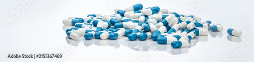 Foto Blue-white antibiotic capsule pills on white background