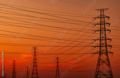 Картината върху платно High voltage electricity transmission towers and power lines silhouetted against sunset sky