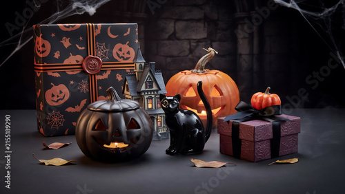 Festive halloween display featuring carved pumpkin gift boxes and black cat ornament on rustic dark table gift box still life