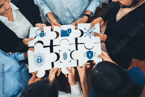 Картината върху платно A diverse team of professionals collaboratively solving a puzzle featuring security icons, symbolizing the significance of collaboration in technology and protection
