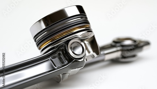 Close-up of a shiny metal piston and connecting rod assembly on a white background.