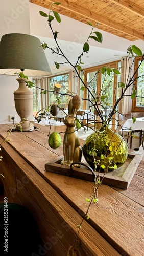 Foto Gemütliche Holzkommode mit Zimmerpflanzen Glasvasen und natürlicher Osterdekorat