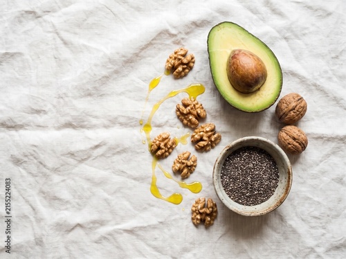 Healthy ingredients for cooking and eating including avocado walnuts and flax seeds.