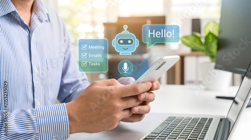 Close up of man holding smartphone with AI chatbot virtual assistant hologram for managing daily tasks and schedules at office desk