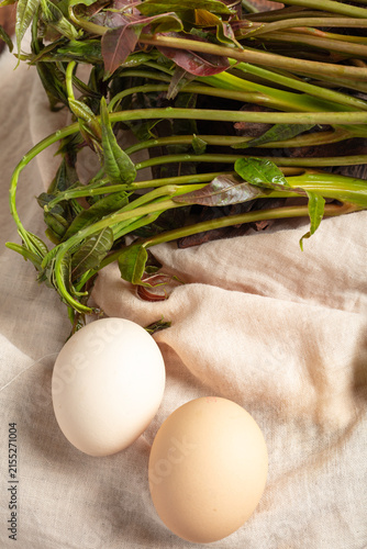 Eggs and leafy greens on fabric background