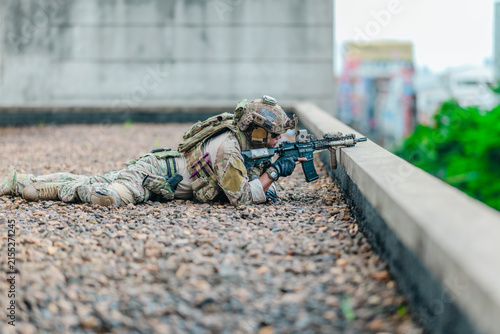 фотографія Military tactical team takes firing position behind rooftop cover during urban o