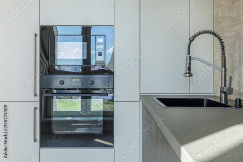Fotografía Modern Kitchen Detail with Built-In Oven, Microwave, and Sink
