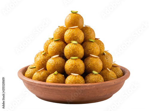 A clay bowl filled with a pyramid of delicious indian sweet motichoor laddu, garnished with slivered pistachios and almonds, isolated on transparent background