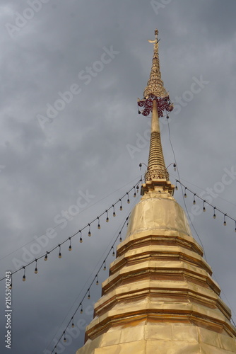 Foto Close-up of the beautiful golden pagoda spire and traditional offerings at Wat Phra That Doi Kham, Chiang Mai