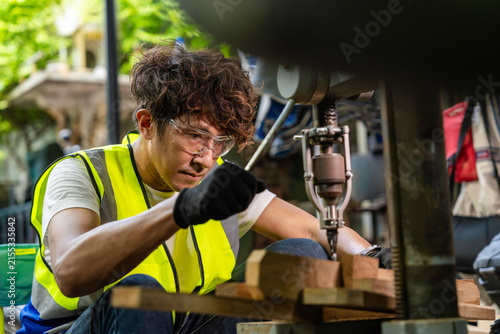 Fotografía Middle aged Thai craftsman in his vintage metal workshop, dad's fist lower near