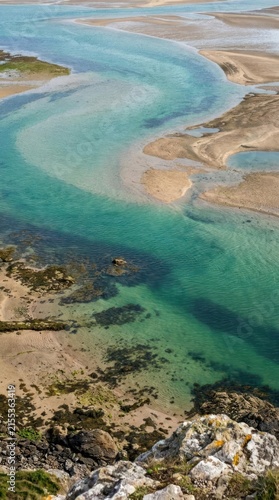 Aerial view of blue winding river through sandy banks.
