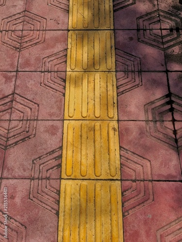 фотографія Yellow tactile paving on pavement pattern