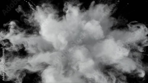 Slow-motion burst of white powdery smoke and fluid ink particles on a black backdrop. Soft d 