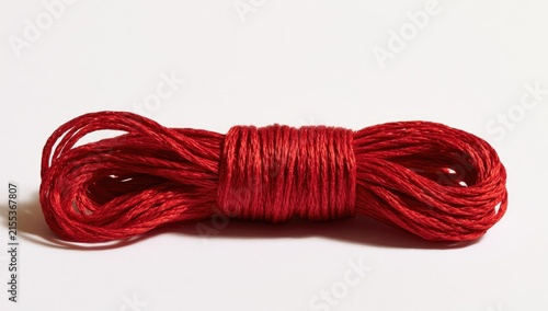 Red Twine String Rolled Up on White Background.